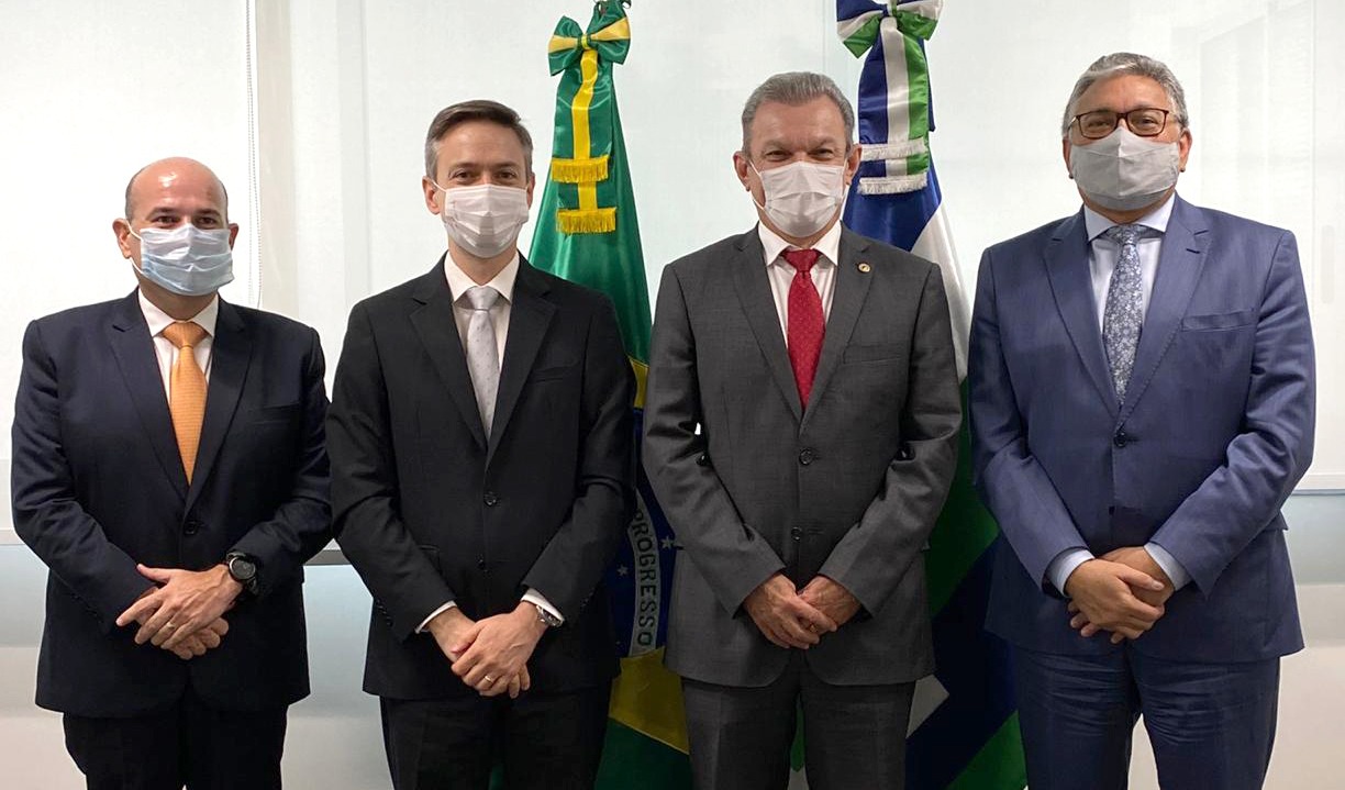 quatro pessoas posam para a foto usando máscaras